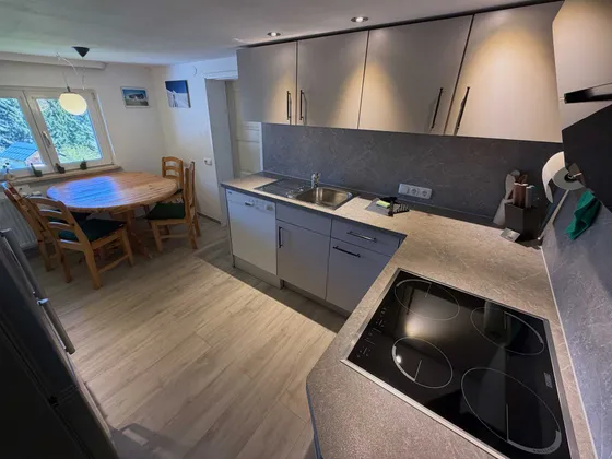 Keuken en eethoek van Appartement 22 met moderne inbouwkeuken, eettafel bij het raam en daglicht