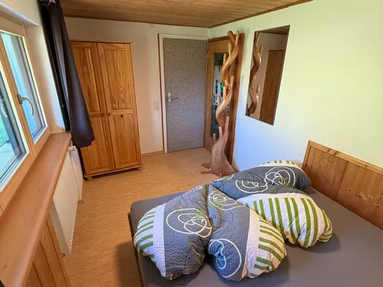 Slaapkamer 2 van Appartement 11 met bed, kast en spiegel