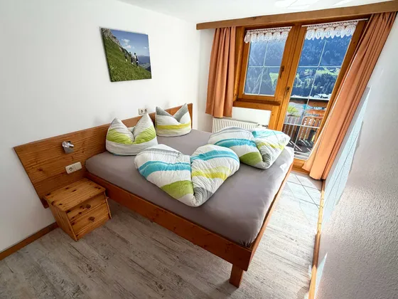 Slaapkamer 1 van Appartement 22 met raam en bergzicht