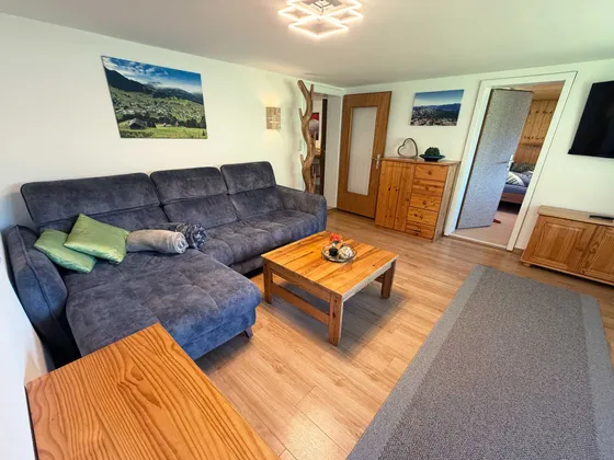 Woonkamer van Appartement 11 met zithoek en houten meubels